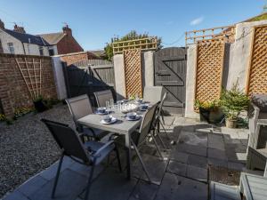 a patio with a table and chairs and a fence at Cliff House in Saltburn-by-the-Sea