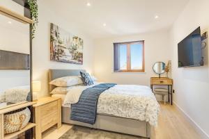 a bedroom with a bed and a tv at The Belfry in Evesham