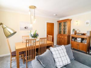 uma sala de estar com uma mesa e um sofá em 2 Chapelstones em Torquay
