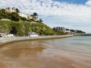 a beach with buildings on a hill next to the water at 2 Chapelstones in Torquay