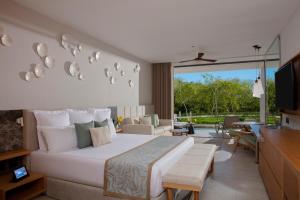 1 dormitorio con 1 cama grande y sala de estar en Secrets Bahia Mita Surf and Spa - All Inclusive - Adults Only, en Punta Mita