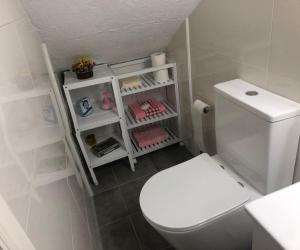 a bathroom with a white toilet and a white shelf at Casa la Torre in Cambados +39 photos