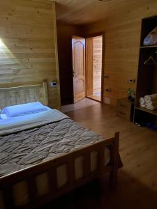 a bedroom with a bed in a wooden room at Guesthouse Demushi in Valbonë