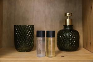 two bottles ofodorizers sitting on a shelf next to a glass container at Riad Medina Mudéjar Cádiz in Chiclana de la Frontera