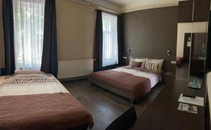 um quarto de hotel com duas camas e duas janelas em Fig Tree House em Budapeste