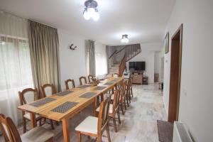a dining room with a long table and chairs at Casa Teju 2 in Slănic