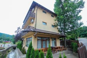 a house with a picnic table in front of it at Casa Teju in Slănic