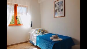 a small bedroom with a blue bed with a window at Villa Priolo in Ciminna