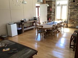 a room with a table and chairs and a kitchen at Pension Casa Simon in Tríacastela