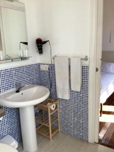 a bathroom with a sink and a mirror and a bed at Pension Casa Simon in Tríacastela