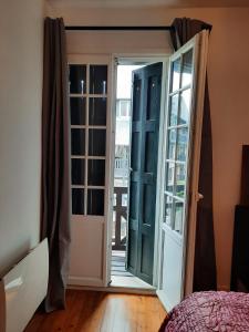 una camera da letto con porta che si apre su un balcone di THE DUKE a Deauville