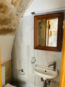 y baño con lavabo y espejo. en Vecchia Casa sterna en Monemvasia