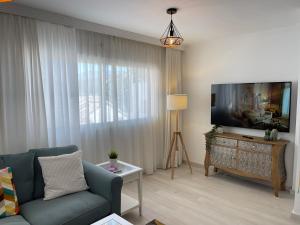 a living room with a couch and a flat screen tv at La Cala Holiday Retreat in La Cala de Mijas