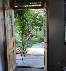 an open door to a porch with a pink chair at Mzia's Garden in Kʼvakhvreli