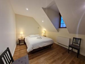 ein Schlafzimmer mit einem weißen Bett und einem Fenster in der Unterkunft Le Faubourg - Gîte et chambres d'hôte in Losne