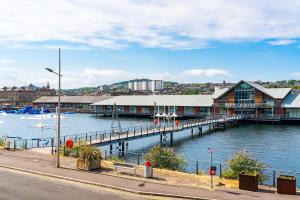 a marina with a dock and a building on the water at Quayside Apartment in Dundee