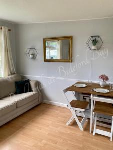a living room with a table and a couch at Bucklands at Bideford Bay in Bucks Mills