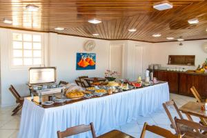 uma mesa longa com comida numa sala em Na Praia Hotel em Porto Seguro