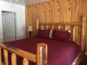 a bedroom with a large wooden bed with purple sheets at Dunsmuir Lodge in Dunsmuir