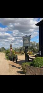 a sign for the entrance to a garden with flowers at Lake View Lodges in Long Melford