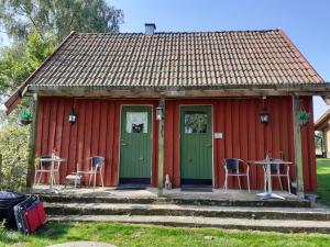 ein rotes Haus mit einem Tisch und Stühlen davor in der Unterkunft Knutstorp Ranch in Tyringe