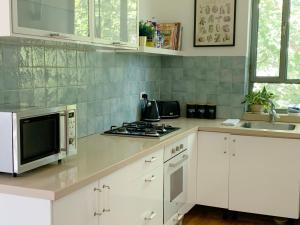 a kitchen with a microwave and a stove top oven at Annie's Boutique Apartment in Jerusalem in Jerusalem