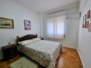 a bedroom with a bed and a window at Apartamento moderno e aconchegante. Pé na areia!!! in Guarujá