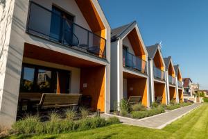 una fila de apartamentos con balcón y banco en Nowa Stodoła, en Władysławowo