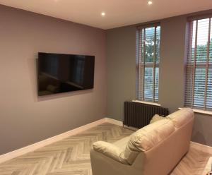 ein Wohnzimmer mit einem Sofa und einem Flachbild-TV in der Unterkunft Costa Del Brid in Bridlington