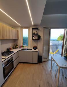 een keuken met witte kasten en een tafel met een eetkamer bij Casa Levante in Isola delle Femmine