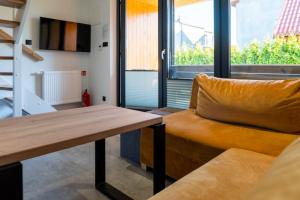 Una sala de estar con una mesa de madera y un sofá. en Nowa Stodoła, en Władysławowo