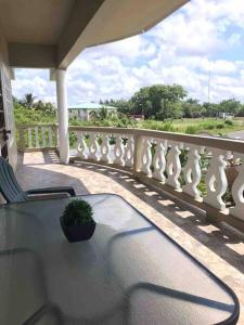 a balcony with a table and a potted plant on it at The Ansen Place in Belmopan