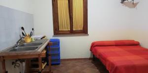 a kitchen with a sink and a bed in a room at Agriturismo Nakelia in Zambrone