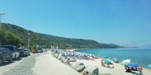 a beach with a bunch of people and umbrellas at Agriturismo Nakelia in Zambrone +12 photos