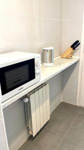 a microwave on a counter in a kitchen at Modern apartment with parking 2 min from the beach in Calella de Palafrugell