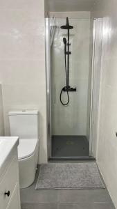 bagno con doccia in vetro e servizi igienici di Modern apartment with parking 2 min from the beach a Calella de Palafrugell