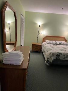 a hotel room with a bed and a mirror at Lovely 2-bedroom condo with pool in Myrtle Beach