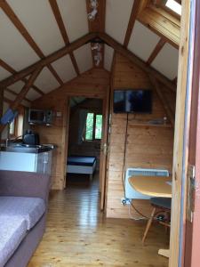une chambre avec un canapé et une table dans une cabine dans l'établissement Bower Pods, à Bowermadden