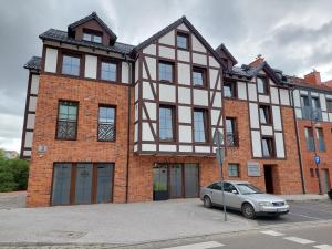 a building with a car parked in front of it at ŁośHouse in Bytów