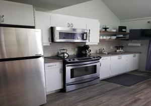 a kitchen with white cabinets and a stainless steel appliance at perfect 'lil condo in Mont-Tremblant