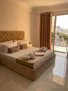 een slaapkamer met een groot bed met handdoeken erop bij Golden Hill Ksamil in Ksamil