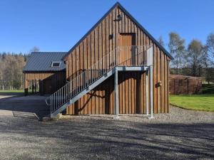 a wooden barn with a staircase on the side of it at Willowbarn Rafford Self Catering in Forres
