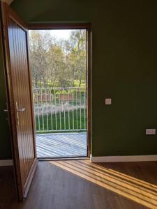 an open door leading to a balcony with a view at Willowbarn Rafford Self Catering in Forres