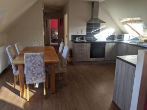 a kitchen with a wooden dining table and chairs at Willowbarn Rafford Self Catering in Forres