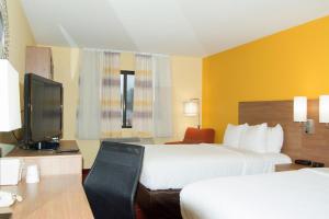 a hotel room with two beds and a television at Days Inn by Wyndham Marquette in Marquette