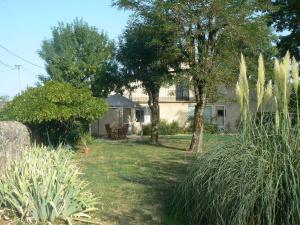 a house with a yard with plants and trees at Maison calme au cœur des vignes in Sainte-Colombe