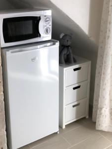 un forno a microonde seduto sopra un frigorifero di Il Dammuso dei Sogni a Modica