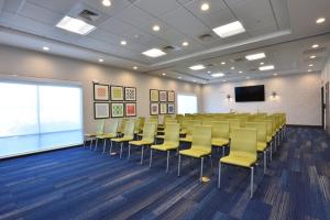 una sala conferenze con sedie gialle e uno schermo di Holiday Inn Express & Suites Spring - Woodlands Area by IHG a Spring Altre 54 foto