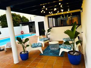 a patio with plants and chairs and a pool at Nazaret Villa with heated pool in Nazaret