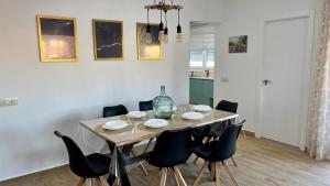 a dining room table with chairs and a bottle on it at Retama chalet - Somhome in Peniscola
